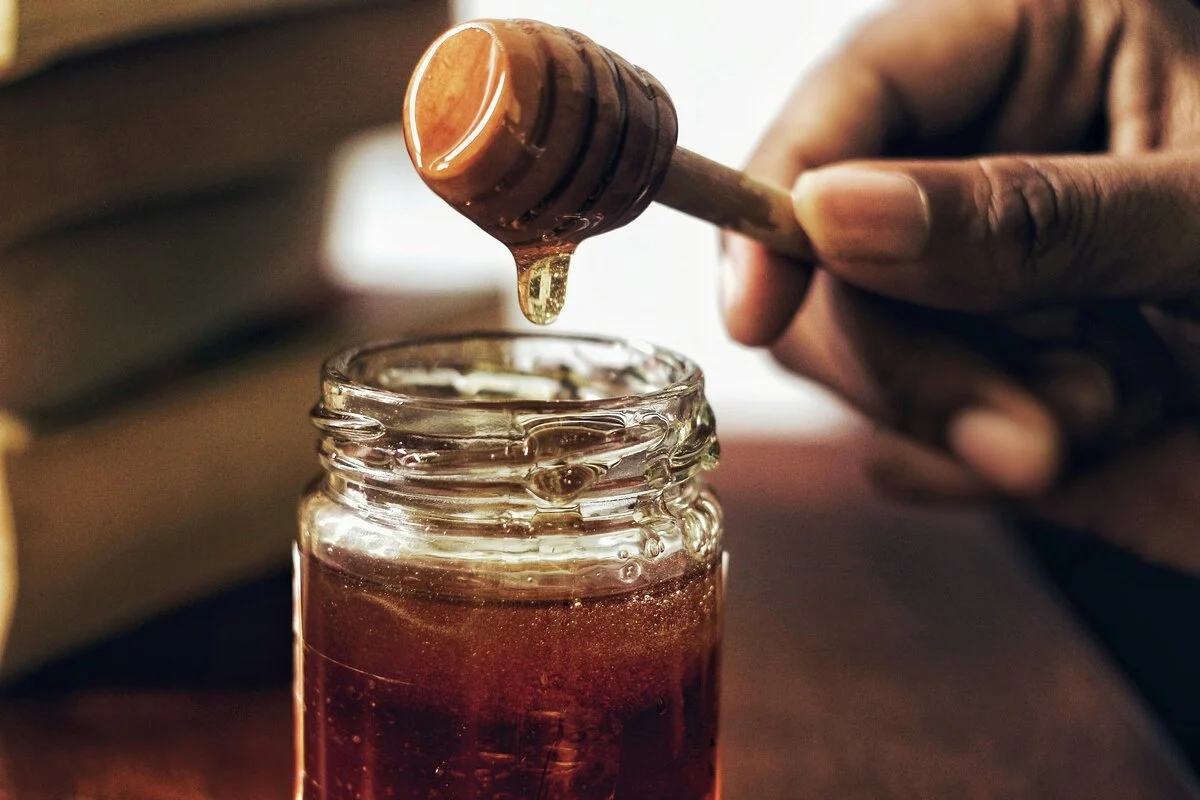 A spoonful of honey, representing its effectiveness as a natural remedy for a range of health issues and promoting healing