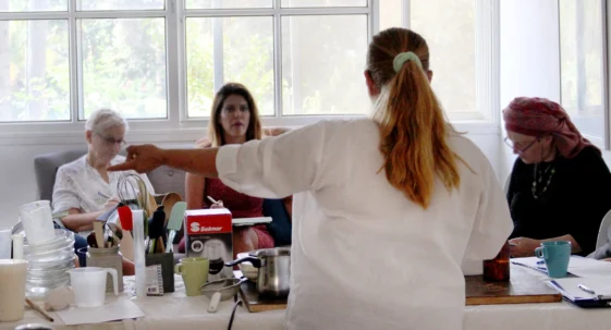 mentor stand in a back view and teaching other 3 woman