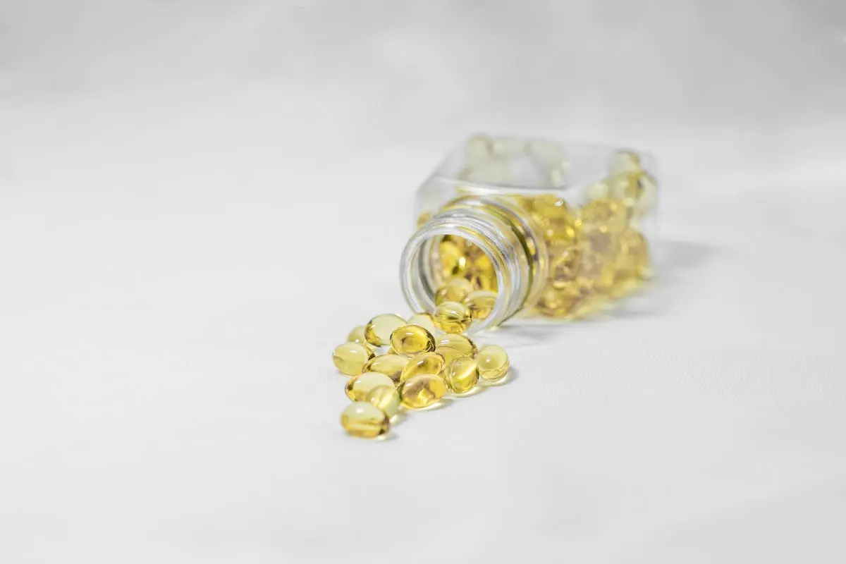 A clear jar containing vibrant Vitamin D capsules